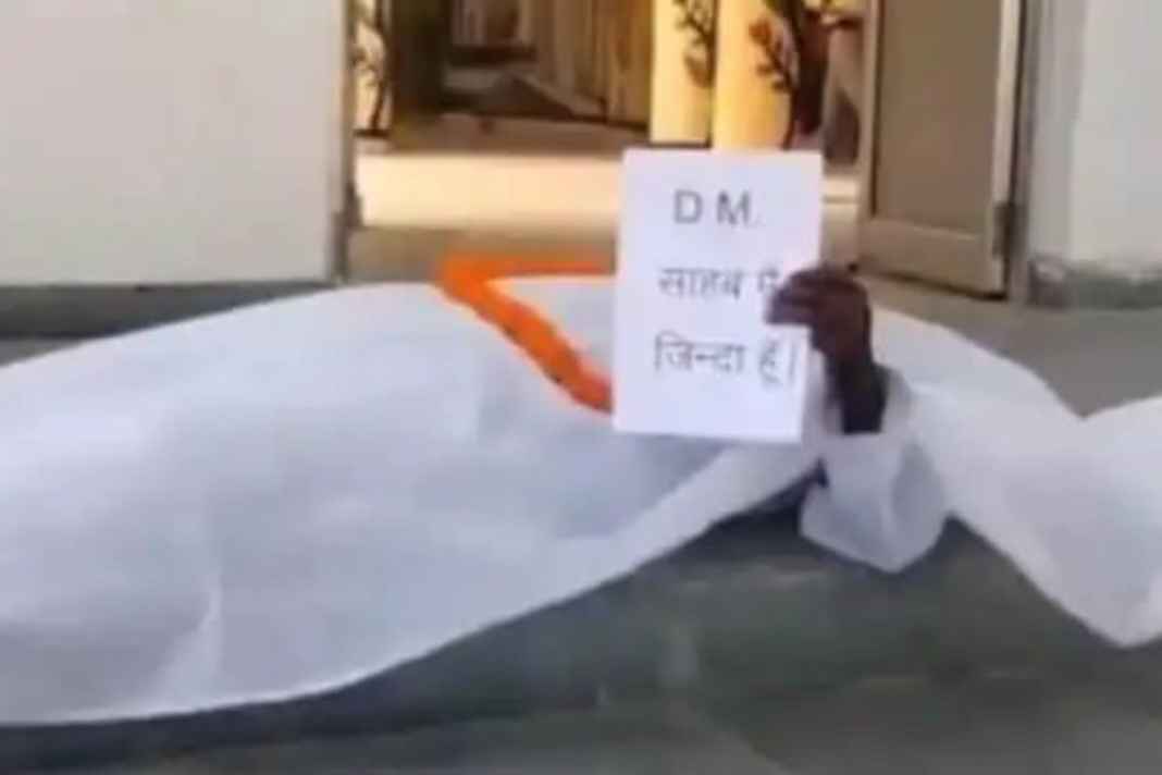 बस्ती का चौंकाने वाला मामला: ‘डीएम साहब मुझे जिंदा कर दो’, कफन ओढ़कर दफ्तर पहुंचा 14 साल से ‘मुर्दा’ बुजुर्ग I am alive